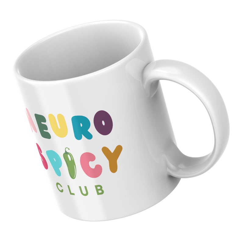May include: White ceramic mug with a colorful graphic that says "Neuro Spicy Club" with a green chili pepper illustration.