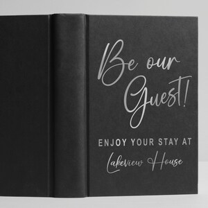 Pu&ograve; includere: Libro nero con scritta argentata "Be our Guest! Enjoy your stay at Lakeview House".