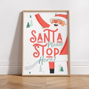 Puede incluir: Un cartel de Navidad imprimible con un Pap&aacute; Noel de dibujos animados con el texto "Santa Please Stop Here!" en letras rojas y verdes.