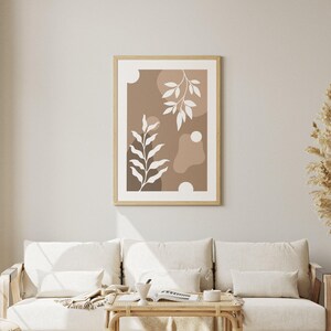 May include: A framed abstract print with a brown background and white stylized leaves. The print features organic shapes in shades of brown.