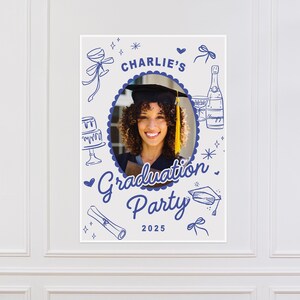 May include: A graduation party poster featuring a photograph of a person in a graduation cap. The poster includes blue illustrations of champagne, a cake, and a scroll. The text reads "Charlie's Graduation Party 2025."