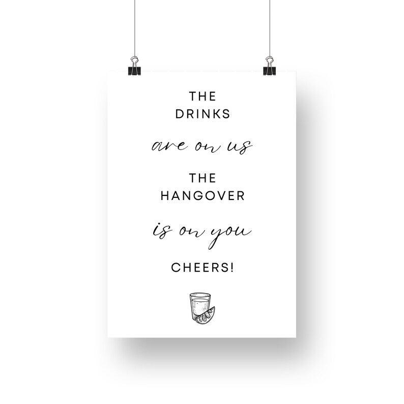 May include: A white sign with black text that reads "The drinks are on us. The hangover is on you. Cheers!" with a black and white illustration of a shot glass with a lime wedge.