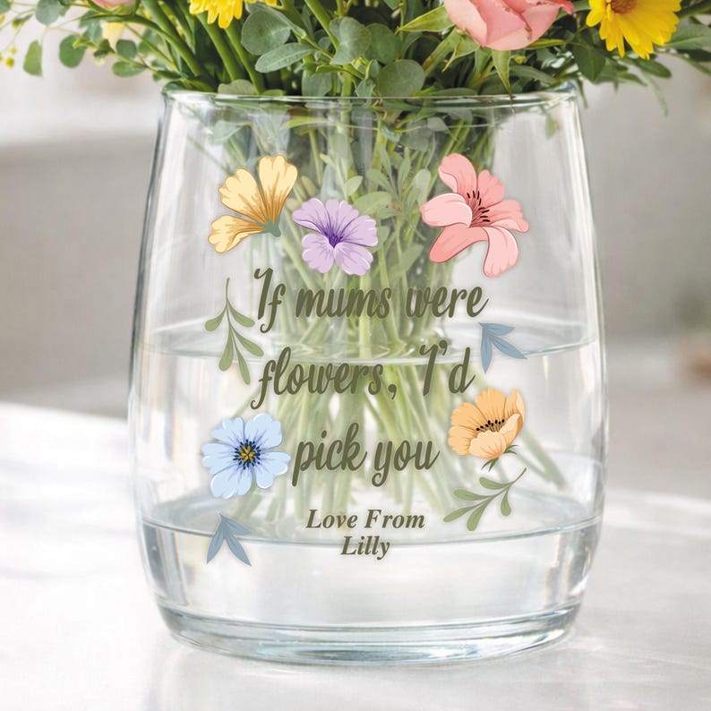 May include: A clear glass vase filled with water and colorful flowers. The vase has a floral design with the text "If mums were flowers, I'd pick you. Love From Lilly."