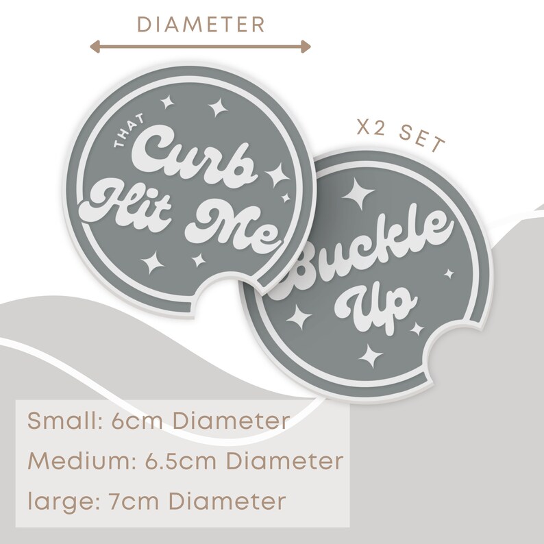May include: Set of two gray round car coasters with white text. One coaster says "That Curb Hit Me" and the other says "Buckle Up".