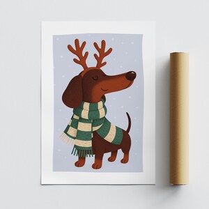 May include: A whimsical illustration of a dachshund wearing reindeer antlers and a green and white striped scarf. The dog is brown with a long snout and a happy expression, set against a light blue background with white dots.