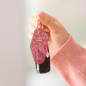 Może przedstawiać: R&oacute;żowy brelok do kluczy z białym obrysem rośliny aloesu i tekstem "Mum, Aloe You So Much!"