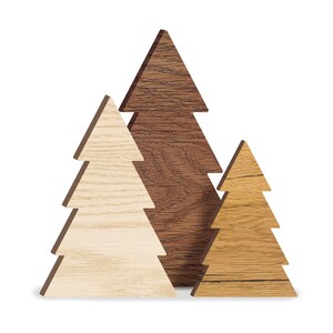 May include: Three wooden Christmas trees in different sizes and shades of brown. The largest tree is dark brown, the middle tree is light brown, and the smallest tree is a medium shade of brown.