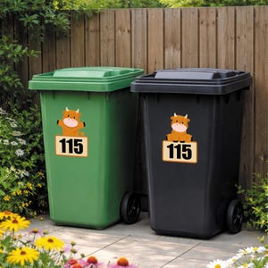 May include: Two outdoor trash cans, one green and one black, with matching lids and wheels. Each can has a sticker featuring a cartoon cow above the number "115". The cans are set against a wooden fence and surrounded by greenery.