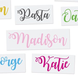May include: A collection of personalized name decals in various colors, including pink, blue, green, and black. The names include "Madison", "Katie", "Pasta", "George", and "Olivia".