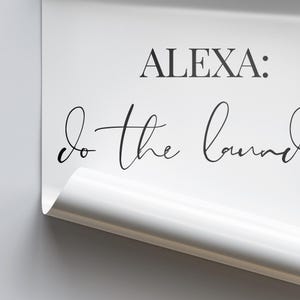 May include: White sign with black text that reads "ALEXA: do the laundry".
