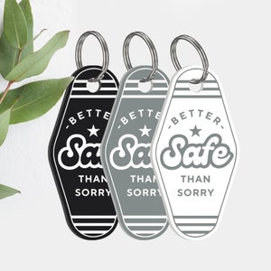 May include: Three motel keychains with the text "Better Safe Than Sorry" in a retro font. The keychains are black, gray, and white.