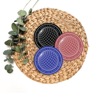 May include: Three round stickers with a globe design and the text "You make the world a better place from the class of 2024". The stickers are black, red, and blue.
