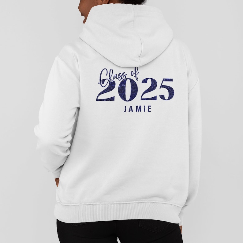 May include: White hooded sweatshirt with the text "Class of 2025" in navy blue script and block letters, with the name "Jamie" below. The sweatshirt has a drawstring hood and a kangaroo pocket.