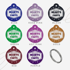 May include: A collection of colorful pet tags in blue, rose pink, black, green, hot pink, gold, red, and purple. Each tag features the text "BREAKIN' HEARTS BLASTIN' FARTS" in a white and black design. A silver split ring is also included.