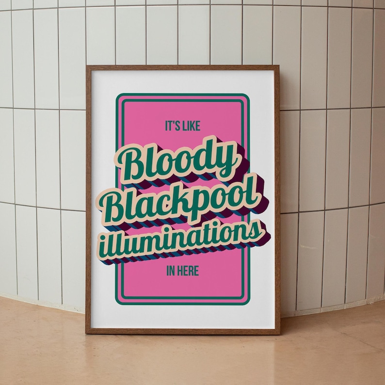 以下が含まれることがあります： 「IT'S LIKE Bloody Blackpool illuminations IN HERE」のテキストがレトロなスタイルで描かれたフレーム付きアートプリント。テキストはティールと白で、紫色の影があり、緑の縁取りのあるピンク色の背景に配置されています。