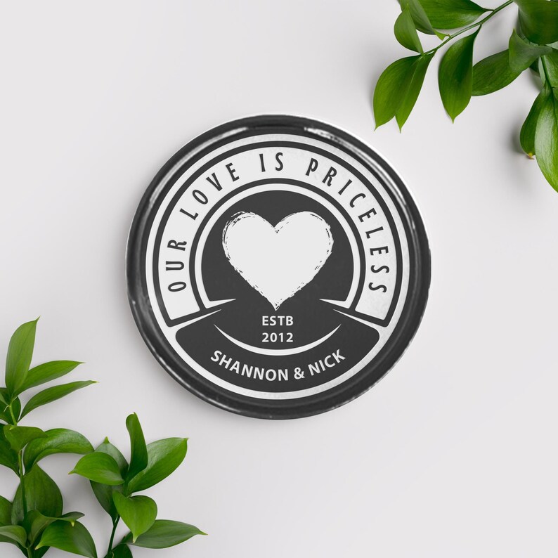 May include: Black and white round plate with the text "Our love is priceless" in a circle around a heart. The text "Estb 2012" is below the heart and the text "Shannon & Nick" is below that.
