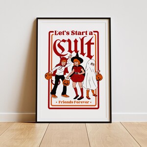 May include: A framed print featuring three children in Halloween costumes. The image includes a child dressed as a devil, a witch, and a ghost, each holding a jack-o'-lantern. The text reads "Let's Start a Cult" and "Friends Forever."