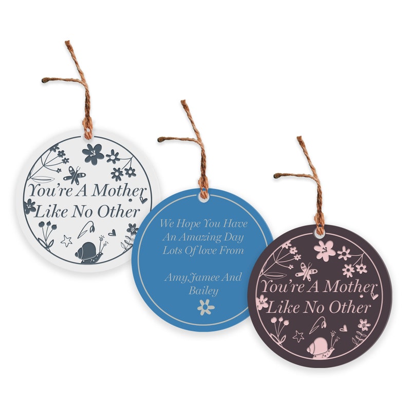 May include: Three round, white, blue, and brown ceramic ornaments with a floral design and the text "You're A Mother Like No Other". The blue ornament also has the text "We Hope You Have An Amazing Day Lots Of love From Amy, Jamee And Bailey".