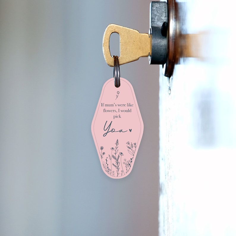 Puede incluir: Un llavero rosa con un dise&ntilde;o floral y el texto "If mum's were like flowers, I would pick You." El llavero est&aacute; unido a una llave de lat&oacute;n en una cerradura de puerta. El llavero tiene un estilo retro de llave de hotel.