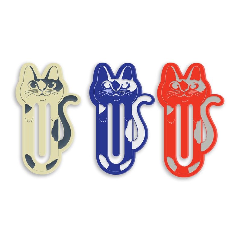 May include: Three cat-shaped bookmark clips in different colors: cream, blue, and red. Each clip features a black and white cat design with a white tail.