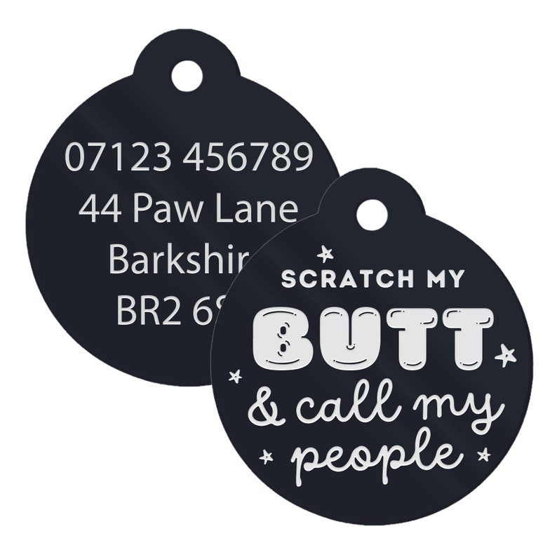 Op de afbeelding: Zwarte ronde hondenpenning met witte tekst. De tekst op de penning luidt "07123 456789, 44 Paw Lane, Barkshir, BR2 6" aan de ene kant en "SCRATCH MY BUTT & call my people" aan de andere kant.