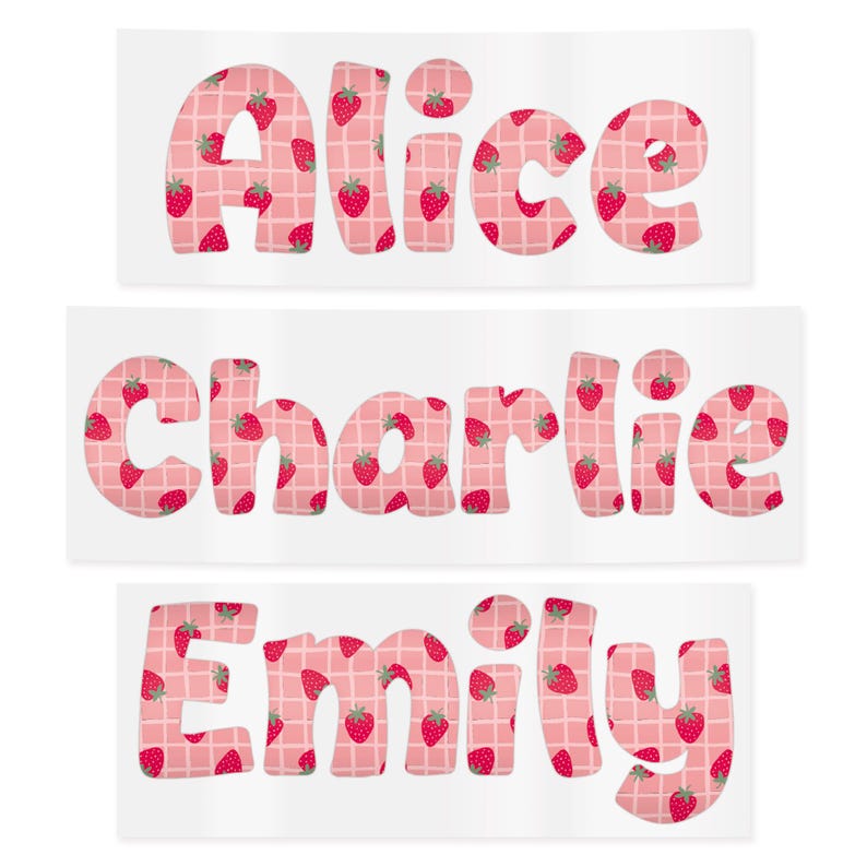 May include: Three rectangular stickers with names: "Alice", "Charlie", and "Emily". Each name is in a bubble letter font, filled with a strawberry pattern on a pink and white checkered background. The strawberries are red with green leaves.