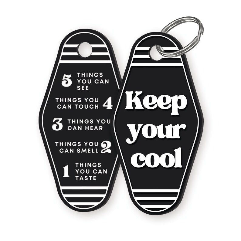 K&ouml;nnte beinhalten: Schwarz-wei&szlig;er Motel-Schl&uuml;sselanh&auml;nger mit dem Text "Keep your cool" auf der einen Seite und einer Liste von Dingen, die man sehen, ber&uuml;hren, h&ouml;ren, riechen und schmecken kann, auf der anderen Seite.