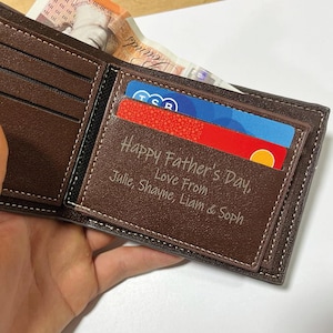 May include: A brown leather wallet with a personalised inscription that reads "Happy Father's Day, Love From Julie, Shayne, Liam & Soph".