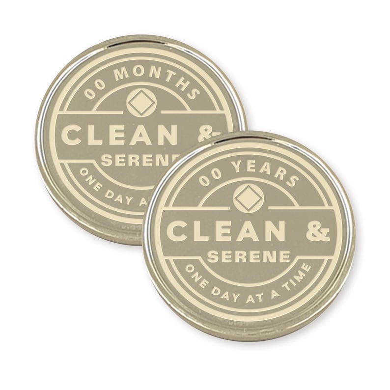 May include: Two silver-colored tokens with a beige background. The tokens feature a diamond symbol and the text "00 MONTHS CLEAN & SERENE ONE DAY AT A TIME" and "00 YEARS CLEAN & SERENE ONE DAY AT A TIME".