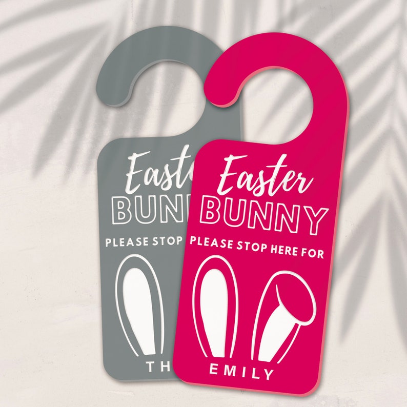 May include: Two door hangers with bunny ears and the text "Easter Bunny" in white. One is pink and says "Please stop here for Emily". The other is gray and says "Please stop here for [name]".