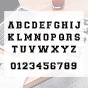 May include: Black and white alphabet and number font with a bold outline. The letters are uppercase and the numbers are in a standard font.