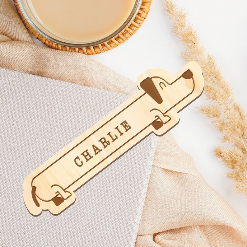 May include: A wooden bookmark shaped like a dachshund with the name "CHARLIE" engraved on it.