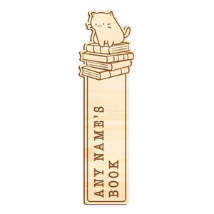 May include: Wooden bookmark with a cartoon cat sitting on top of a stack of books. The bookmark is engraved with the text "ANY NAME'S BOOK".