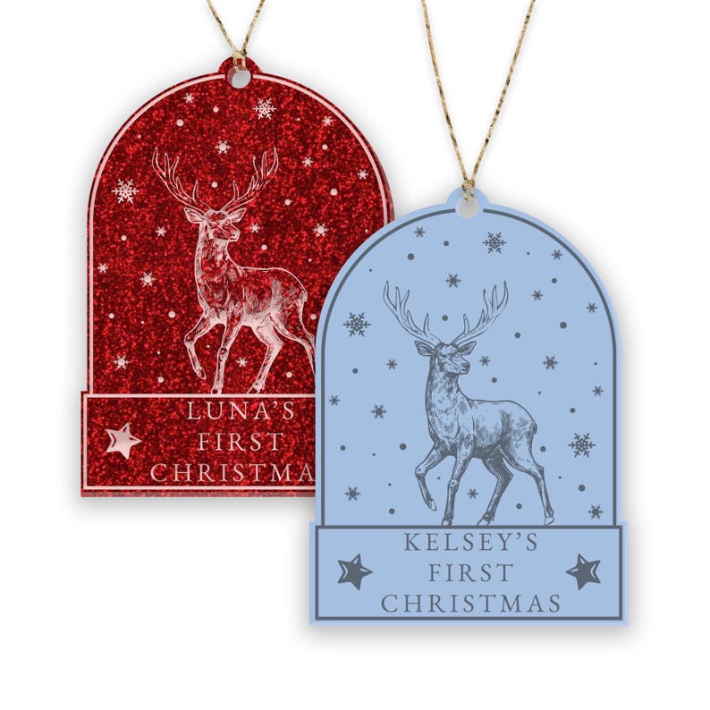 May include: Two Christmas ornaments featuring a deer in a snow globe design. The ornament on the left is red with glitter and says "Luna's First Christmas". The ornament on the right is blue and says "Kelsey's First Christmas".