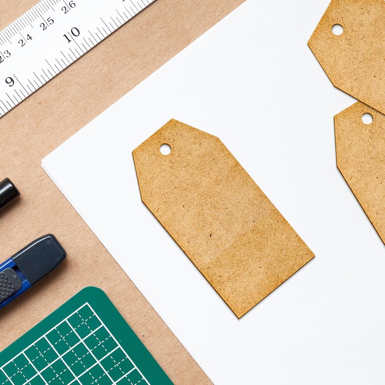 May include: Three blank brown paper tags with rounded corners and a hole punched in the top. The tags are on a white surface.