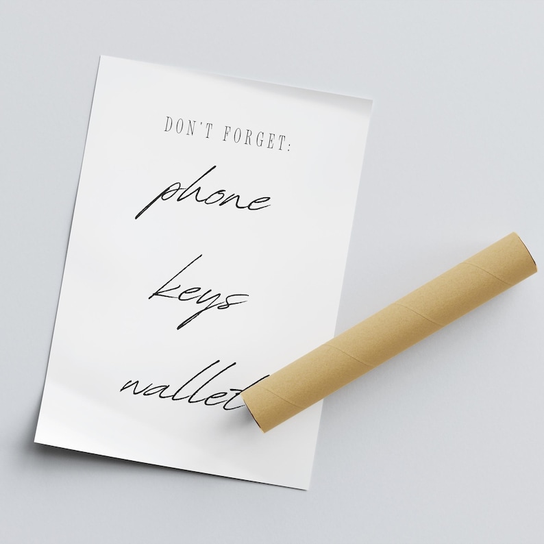 May include: A white poster with the text "DON'T FORGET: phone keys wallet" written in black cursive.