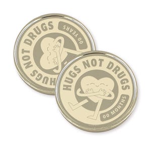 May include: Two gold-colored metal coins with a white background. The coins feature a cartoon heart character hugging itself with the text "Hugs Not Drugs" and "00 Months" or "00 Years" on each coin.