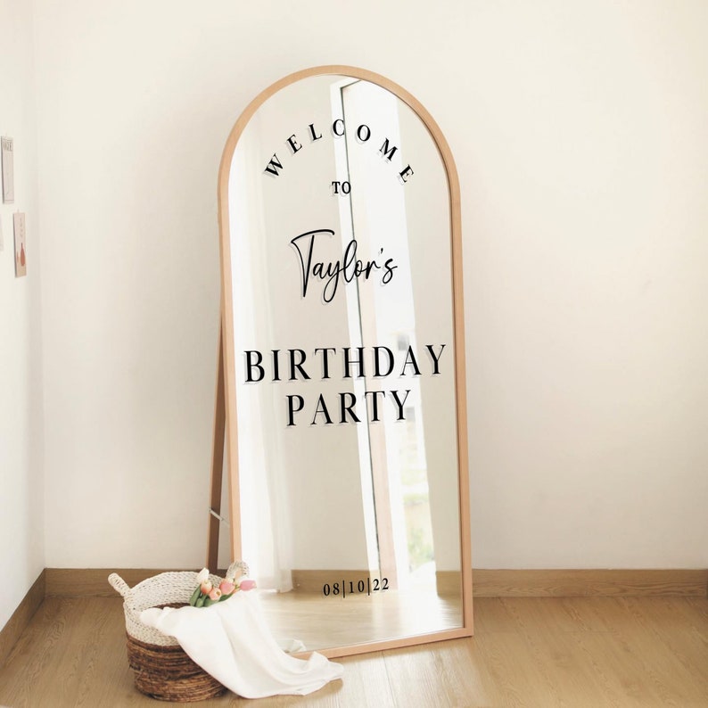May include: A full-length mirror with a wooden frame in the shape of an arch. The mirror has a black vinyl sticker that says "Welcome to Taylor's Birthday Party 08|10|22".