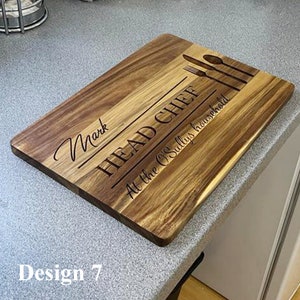 May include: A wooden cutting board with the text "Head Chef" and "At the O'Sullivans household" engraved on it. The name "Mark" is also engraved on the board. The board has a natural wood finish.