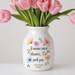 May include: A white ceramic vase with a bouquet of pink tulips. The vase is decorated with colorful floral illustrations and the text "If mums were flowers, I'd pick you. Love From George."