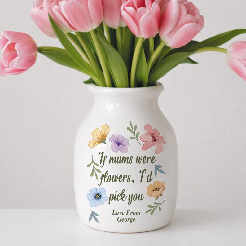 May include: A white ceramic vase with a bouquet of pink tulips. The vase is decorated with colorful floral illustrations and the text "If mums were flowers, I'd pick you. Love From George."