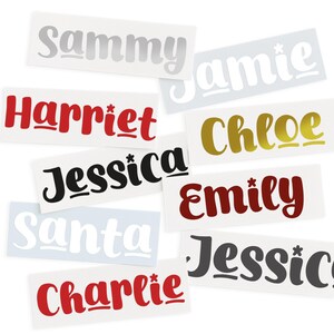 May include: A collection of name decals in various colors and fonts. Names include "Sammy", "Jamie", "Harriet", "Chloe", "Jessica", "Emily", "Santa", "Jessica", and "Charlie". The decals are on white rectangular backgrounds.