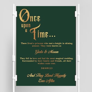 May include: A green wedding sign with gold lettering that reads "Once upon a time... There lived a princess who met a knight in shining armor. They were known as Greta & Mason. They fell in love and had the most magical wedding. Surrounded by their family and friends, all their wishes came true. 30/09/23 And They Lived Happily Ever After."
