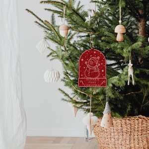 May include: Red glitter Christmas ornament with a snowman design and the text "Oliver's First Christmas".
