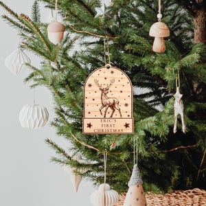 Op de afbeelding: Houten kerstversiering met een rendierontwerp en de tekst "Eric's First Christmas".