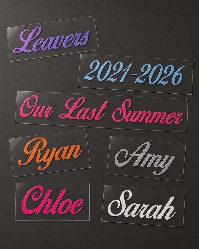May include: A collection of clear acrylic name tags and labels with various text in different colors. The labels include the words "Leavers", "2021-2026", "Our Last Summer", "Ryan", "Amy", "Chloe", and "Sarah". The text is in a cursive font.