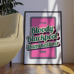 以下が含まれることがあります： 「IT'S LIKE Bloody Blackpool illuminations IN HERE」のテキストが入ったフレーム付きポスター。テキストはレトロスタイルで、ピンクの背景にティールと白の文字。フレームは黒です。