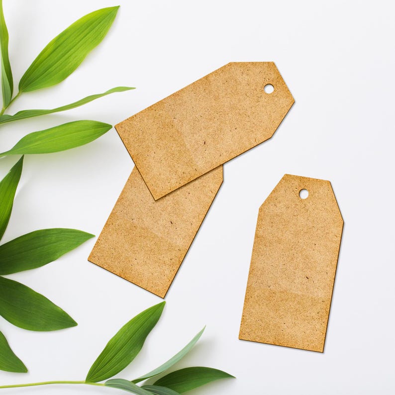 May include: Three brown paper gift tags with a hole punched in the top. The tags are on a white background with green leaves.