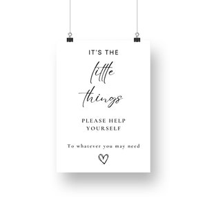 May include: A white sign with black text that reads "It's the little things. Please help yourself to whatever you may need." A small heart is drawn at the bottom of the sign.