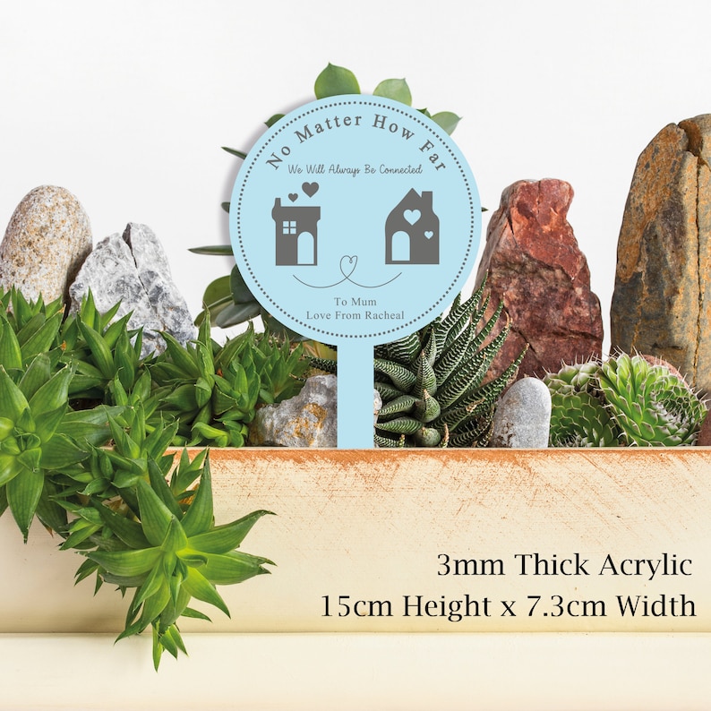 May include: A light blue acrylic garden stake with the text "No Matter How Far We Will Always Be Connected" and two house silhouettes with hearts. The text "To Mum Love From Racheal" is also included. The stake is 3mm thick, 15cm high and 7.3cm wide.